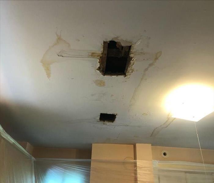 Hole in the kitchen ceiling and water stain marks