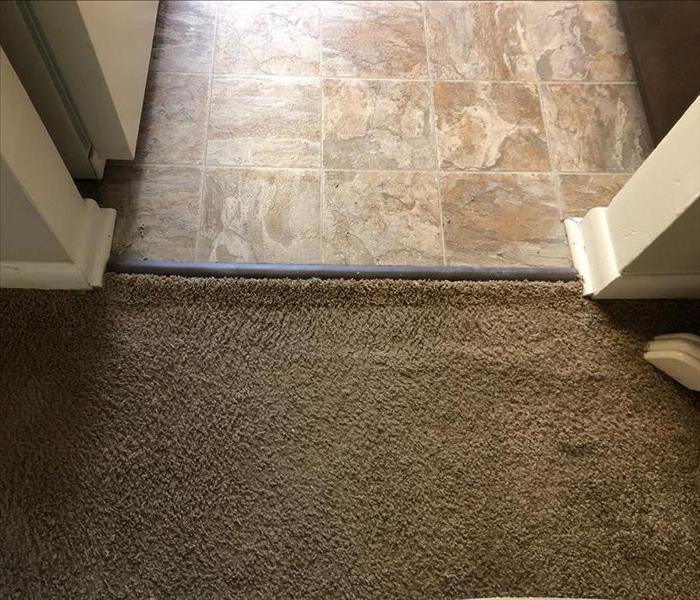Carpet seam attached under transition strip